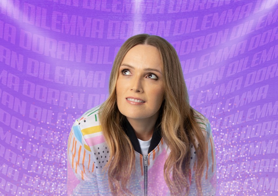 Image of comedian Emma Doran in front of a purple background.